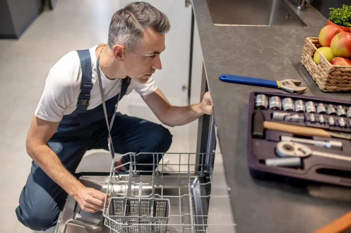 Dishwasher repair technician inspecting an open dishwasher in Toronto